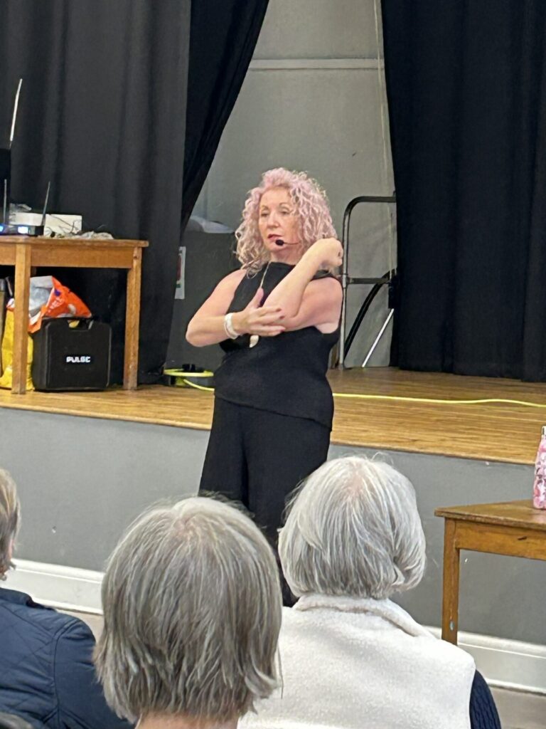 Lindsey Barrell showing the sign for "Biscuit" at her BSL talk on 26th Sept 2025