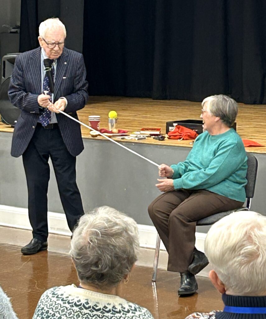 John Richard with member helping with his magic.